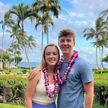 a man and a woman standing in front of the ocean