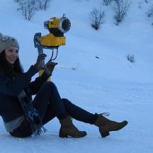 eine Frau sitzt im Schnee und hält ein Snowboard