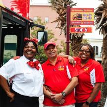 a group of three people standing in front of a bus
