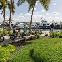 a group of people riding bikes near a marina