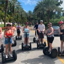 a group of people riding on segifts down a street