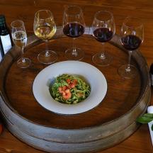 a wooden table with a plate of food and wine glasses