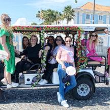 a group of women riding in a golf cart