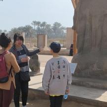two women and a boy looking at a statue