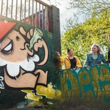 eine Gruppe von Menschen steht an einer Wand mit Graffiti