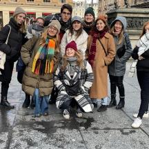 a group of people posing for a picture on a sidewalk