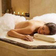 eine Frau, die mit einem Handtuch in einer Badewanne liegt