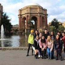 a group of people posing for a picture in front of a fountain