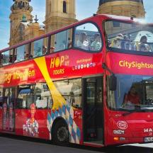 červený dvoupatrový autobus jedoucí po ulici