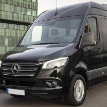a black van is driving down a street