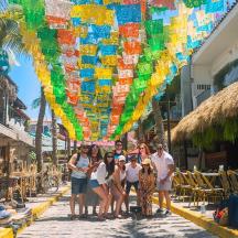 un grup de persones dretes al carrer sota un paraigua de colors