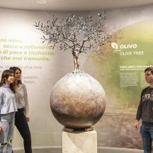 a group of people looking at a vase in a museum