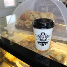a cup of coffee sitting next to a tray of donuts