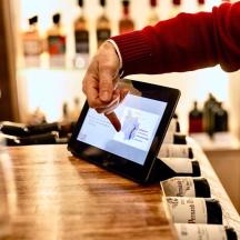 a person is pointing at a laptop on a table