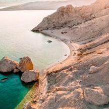 a beach with rocks and a boat in the water