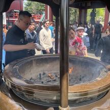 a crowd of people standing around a fire pit
