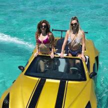 two women sitting on a yellow boat in the water