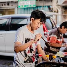 two men are preparing food at a table