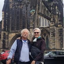 a man and woman standing in front of a church