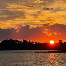 a sunset over a body of water with the sun setting