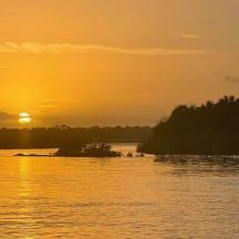 a sunset over a body of water with a island