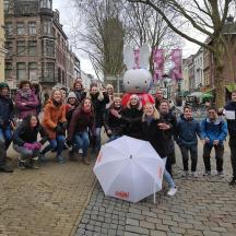 a group of people posing for a picture on a street