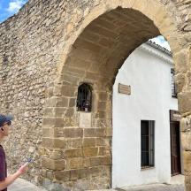 младић стоји поред камене зграде