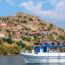 un vaixell a l'aigua davant d'una muntanya