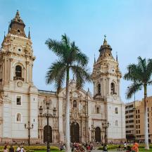 a large building with two towers and palm trees