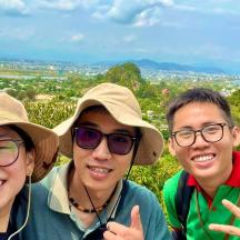 three people are posing for a picture on a mountain