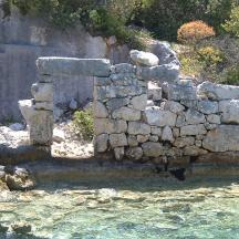 an old stone wall next to a body of water
