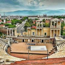 an amphitheater with a stage in front of a city