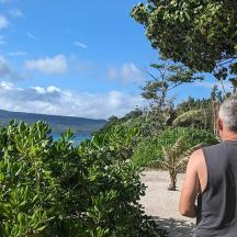 un home dret a la platja mirant l'aigua