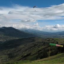 a kite flying in the sky over a hill
