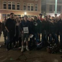 eine Gruppe von Menschen steht vor einem Gebäude