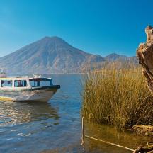 a boat in the water with a mountain in the background