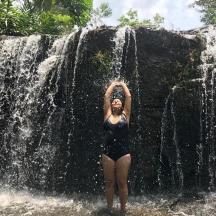 a woman standing in front of a waterfall