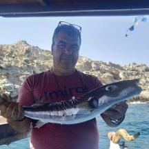 ein Mann, der einen Fisch in seinen Händen hält