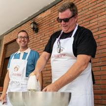 due uomini in cucina che preparano il cibo su un tavolo