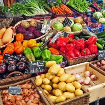 una mostra de fruites i verdures en cistelles en un mercat