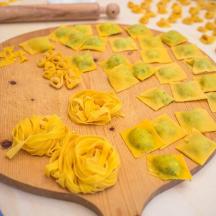 a wooden cutting board with pasta on a table