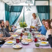 en gruppe mennesker sidder omkring et bord og spiser
