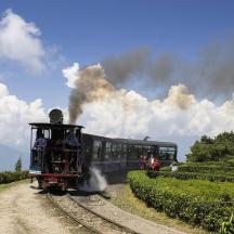 a train traveling down the tracks with smoke coming
