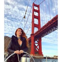a woman sitting on a boat in front of a bridge