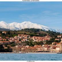 una città sulla riva di uno specchio d'acqua con montagne innevate
