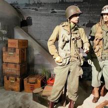 två män i militäruniformer står bredvid lådor