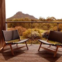 two chairs on a deck with a view of a mountain