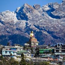 a city with a statue in front of a mountain