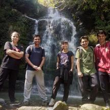 eine Gruppe von Menschen steht vor einem Wasserfall