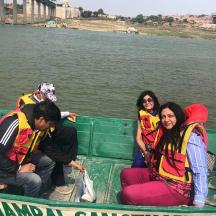 a group of people sitting in a boat on the river